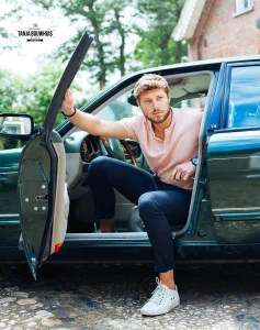a man sitting in a car with his door open