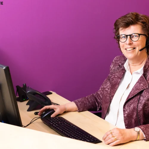 Vrouw achter bureau met computer.